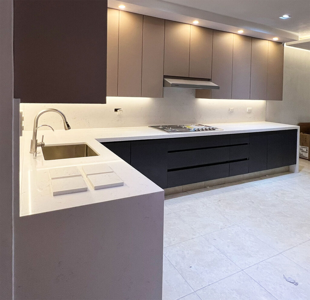 Cocina integral moderna en Valle Real Zapopan con acabados en tono taupe y herrajes de precisión.