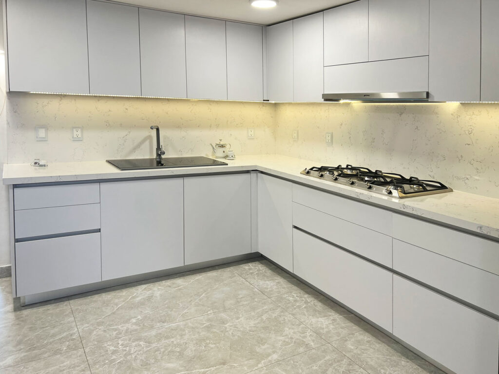Cocina minimalista blanca antihuella con cubierta de cuarzo blanco