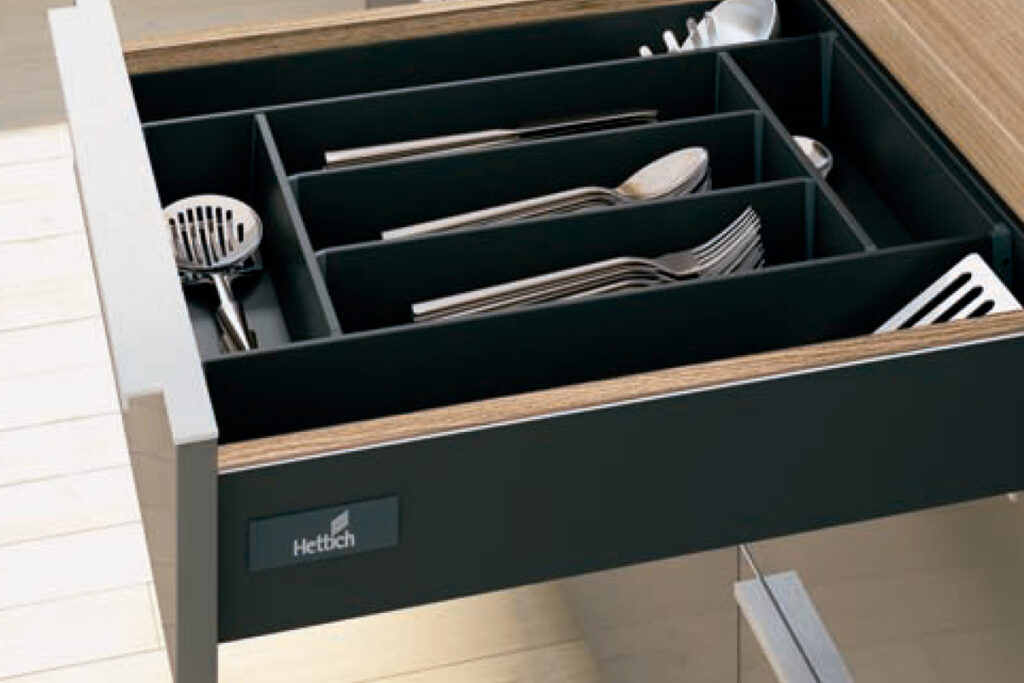 Cajón de alta precisión Hettich con organizador interno, demostrando la ingeniería alemana y operatividad silenciosa en cocinas Hauska.